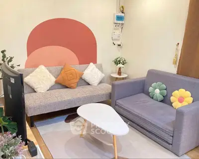 Charming living room with modern decor, featuring cozy sofas, stylish cushions, and a unique wall design.
