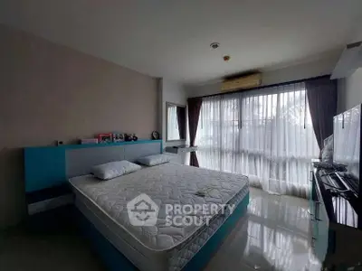 Spacious bedroom with large windows and modern furnishings