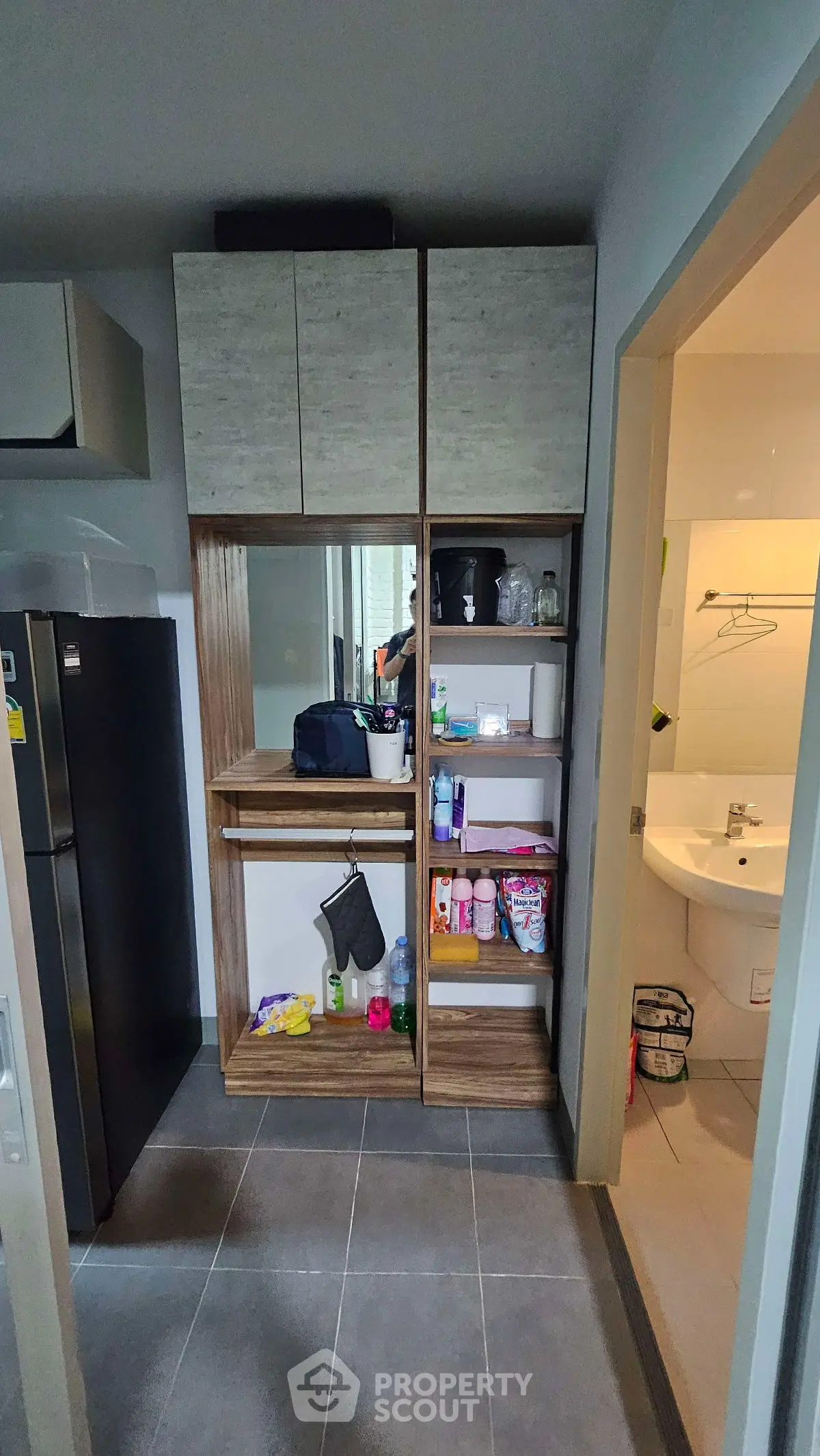 Compact kitchen with modern shelving and adjacent bathroom view