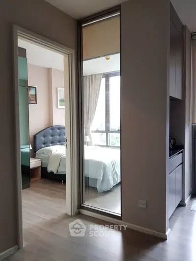 Modern bedroom with large window and stylish decor in a high-rise apartment.