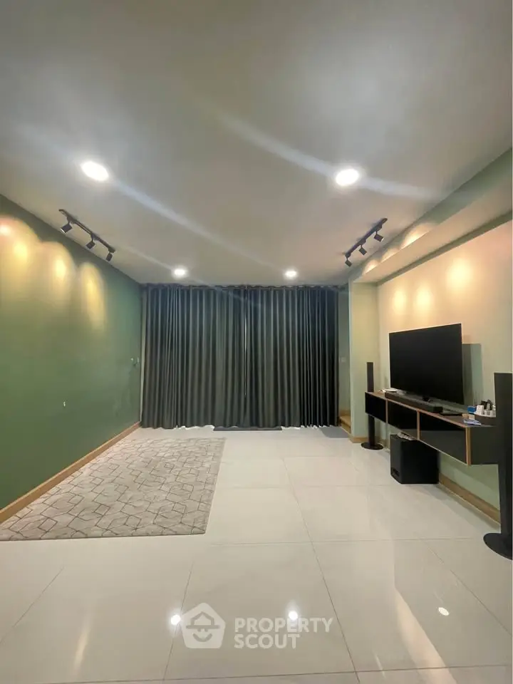 Spacious living room with modern decor and large TV setup