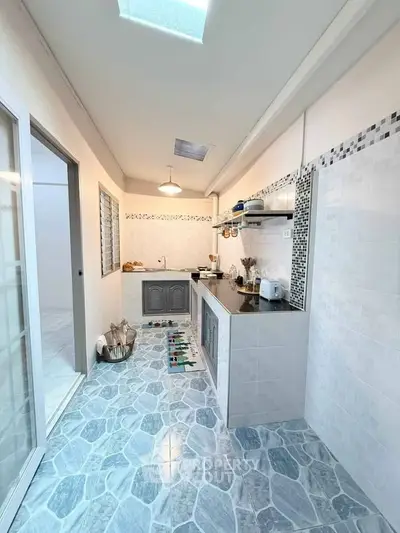 Modern kitchen with sleek design and ample natural light, featuring stylish tile flooring and contemporary appliances.