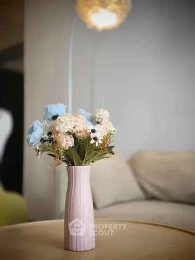 Elegant living room with stylish decor and floral centerpiece on a wooden table.