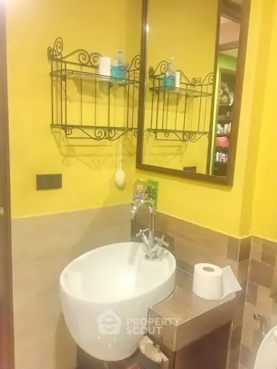 Charming bathroom with vibrant yellow walls and elegant fixtures