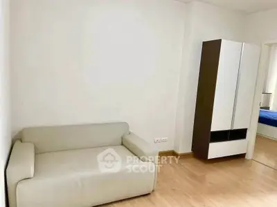 Minimalist living room with modern sofa and sleek wardrobe, perfect for compact urban living.
