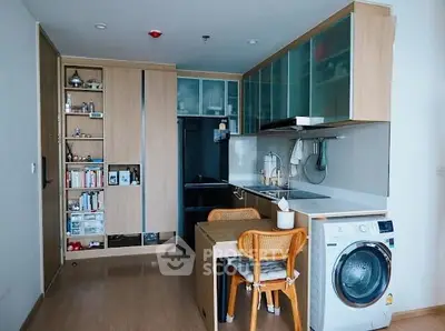 Modern kitchen with washing machine and dining area in stylish apartment.