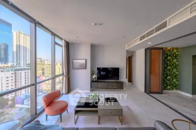 Spacious modern living room with large windows offering stunning city views, stylish furniture, and elegant decor.