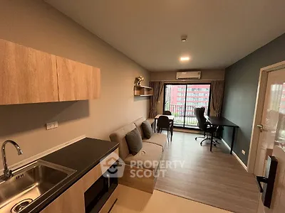 Modern living room with balcony, featuring sleek furniture and natural light.