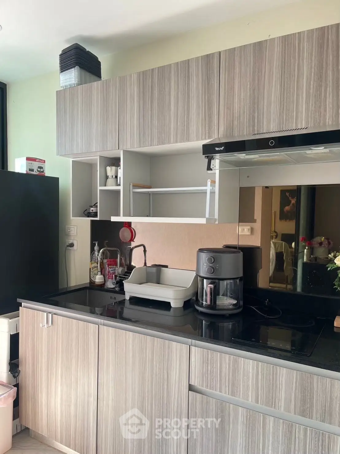 Modern kitchen with sleek cabinetry and appliances, featuring a coffee maker and ample counter space.