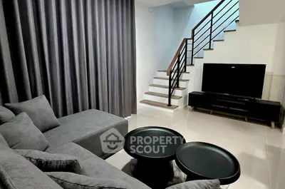 Modern living room with sleek staircase and stylish furniture