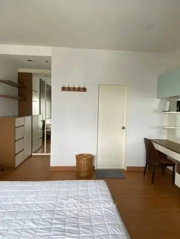Modern bedroom with built-in storage and study area, featuring sleek design and ample natural light.