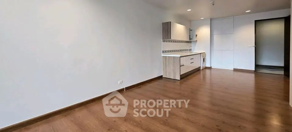 Spacious modern living room with open kitchen and wooden flooring