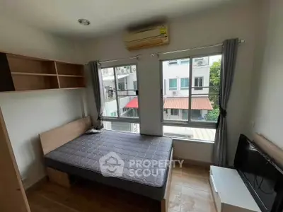 Cozy bedroom with large windows and modern furnishings in a bright apartment.
