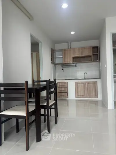 Modern kitchen with dining area featuring sleek cabinetry and tiled flooring.