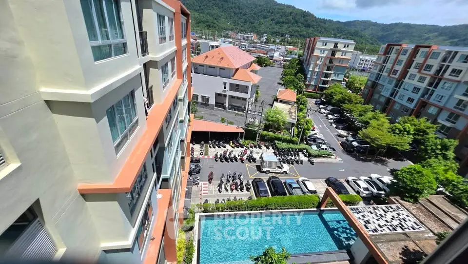 Stunning aerial view of modern apartment complex with pool and lush surroundings, perfect for urban living.