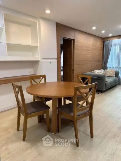 Modern living room with wooden dining set and cozy seating area, perfect for relaxation and entertaining.