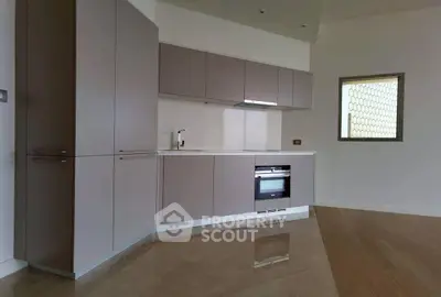 Modern kitchen with sleek cabinetry and built-in oven in a minimalist design.