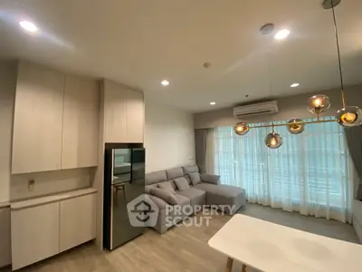 Modern living room with stylish lighting and large windows in a cozy apartment.