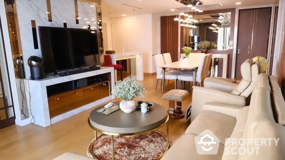 Spacious living room with modern furnishings, large TV, and elegant dining area, perfect for entertaining and relaxation in a luxurious setting.