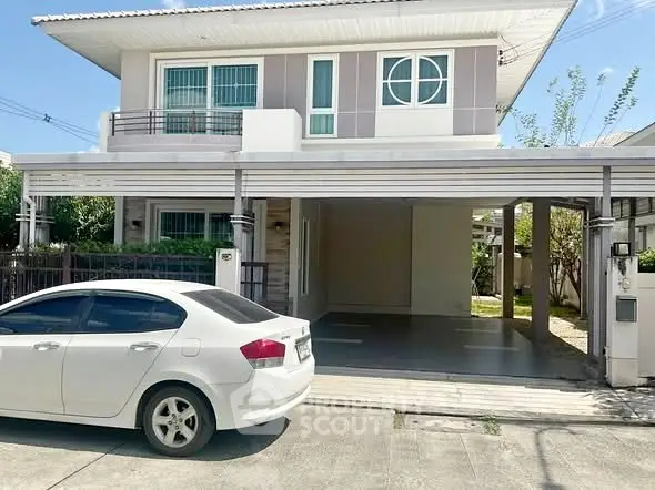 Modern two-story house with carport and white sedan parked in driveway.
