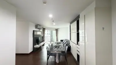 Spacious modern living room with dining area and large windows in a stylish apartment.