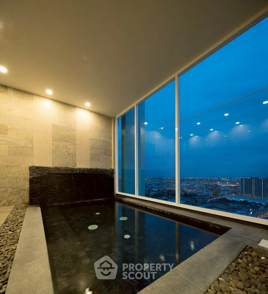 Luxurious indoor pool with stunning city view at dusk