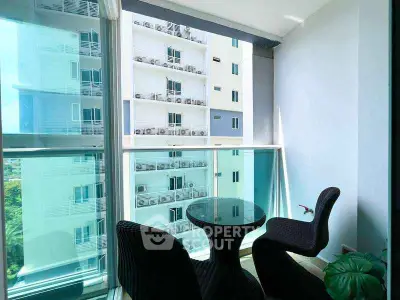 Chic urban balcony with modern seating and stunning city view, perfect for relaxation.