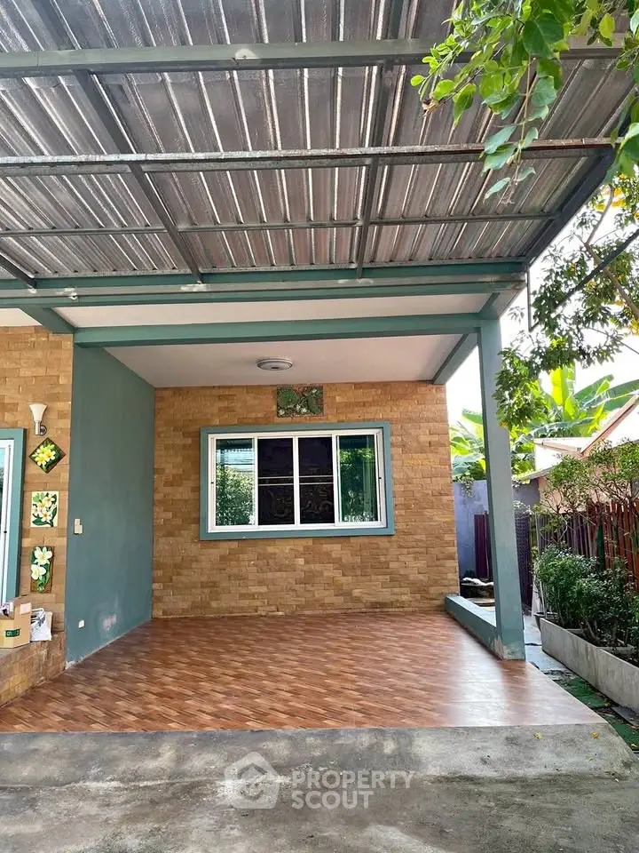 Charming covered patio with brick accents and lush greenery, perfect for relaxation and outdoor gatherings.