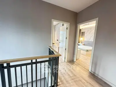 Modern interior hallway leading to a stylish bedroom with elegant decor and wooden flooring.