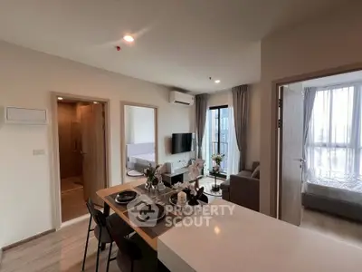 Modern open-plan living room with dining area and natural light in a stylish apartment.