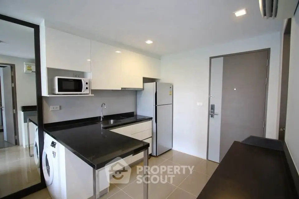 Modern kitchen with sleek appliances and stylish black countertops