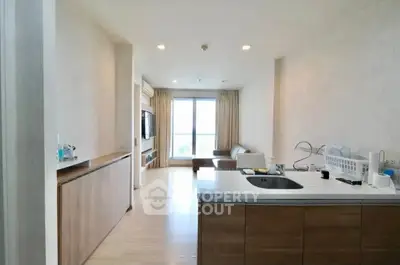 Modern open-layout living room with kitchen island and large window view.