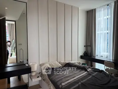 Modern bedroom with stylish decor and large window offering natural light