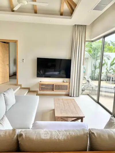 Modern living room with large TV and sliding glass doors to patio