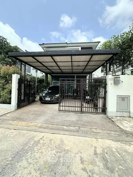 Modern house with covered parking and sleek design in a suburban setting.