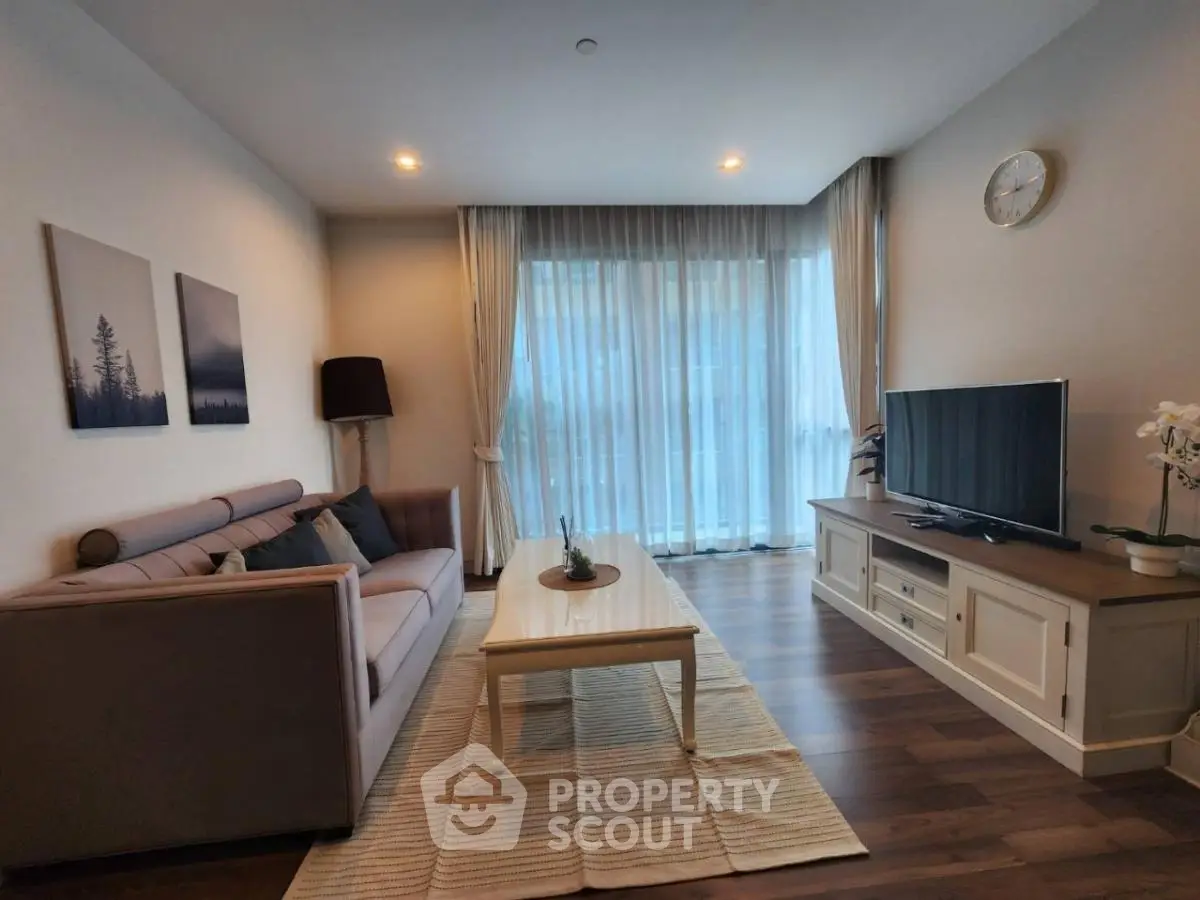 Charming living room with cozy sofa, stylish decor, and large window for natural light.
