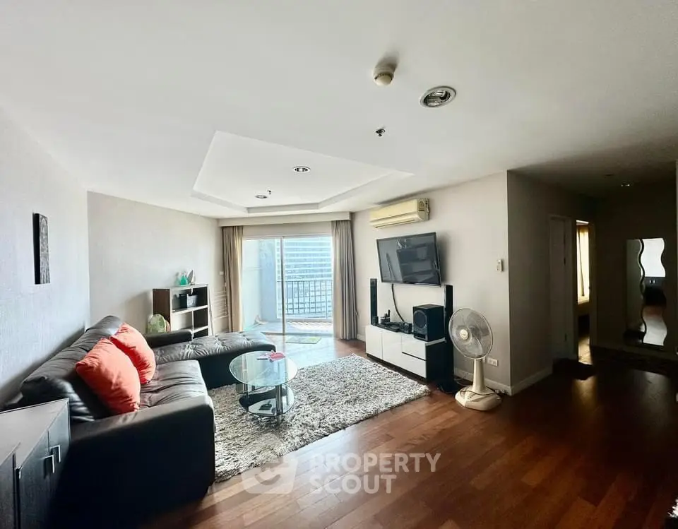 Spacious living room with modern decor and balcony view in a stylish apartment.