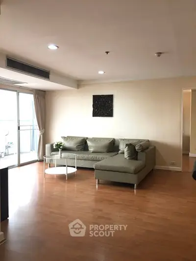 Spacious living room with modern sofa and natural light in elegant apartment.