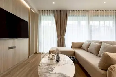 Modern living room with elegant decor and large windows offering natural light.