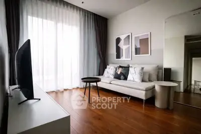 Modern living room with elegant decor and large window, featuring a cozy sofa and sleek wooden flooring.
