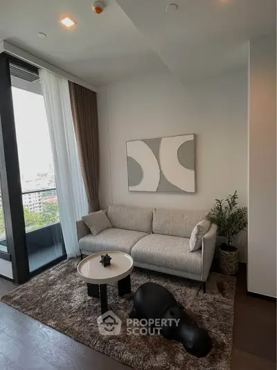 Stylish modern living room with cozy sofa, abstract art, and city view from large window.