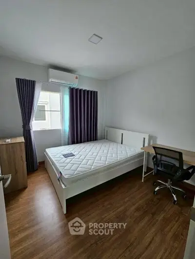 Modern bedroom with wooden flooring, large window, and minimalist furniture in a bright apartment.