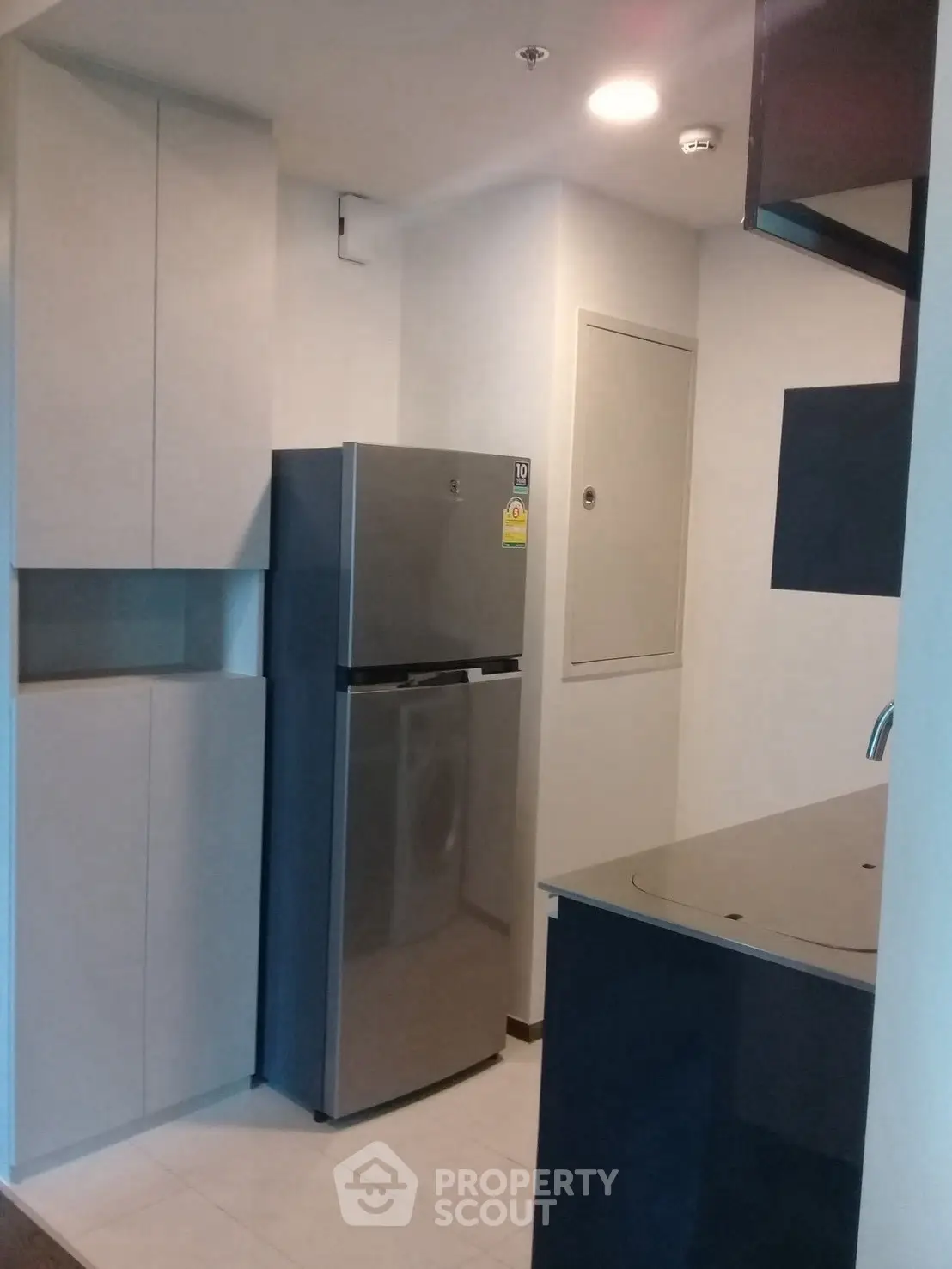 Compact modern kitchen with sleek cabinets and stainless steel fridge