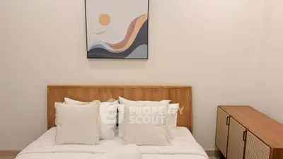 Cozy bedroom with modern art and wooden furniture, perfect for relaxation.