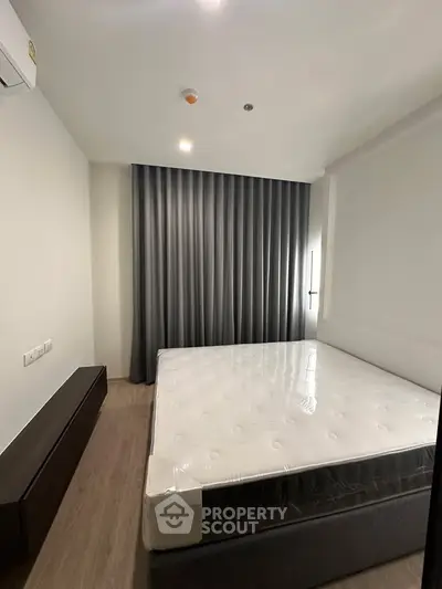 Modern bedroom with sleek design, featuring a comfortable bed and stylish curtains, perfect for relaxation.