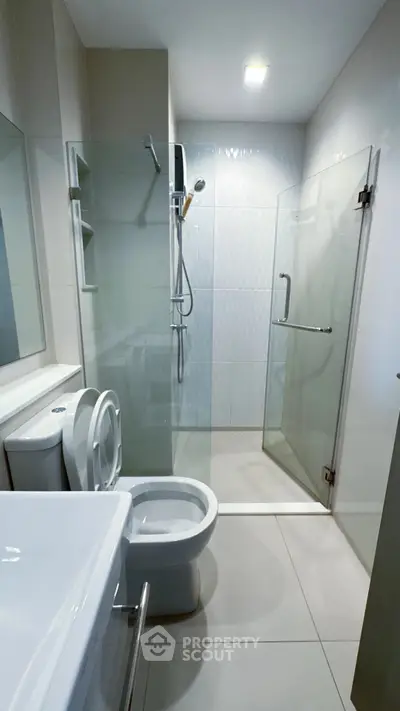Modern bathroom with glass shower enclosure and sleek fixtures.