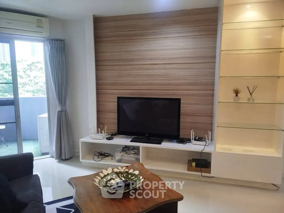 Modern living room with sleek TV unit and balcony access