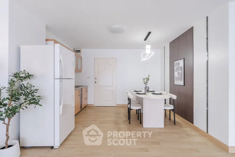 Modern kitchen with dining area, featuring sleek design and contemporary lighting.