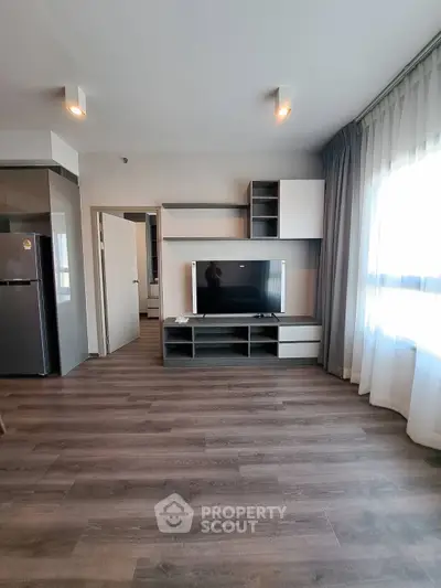 Modern living room with sleek TV unit and large window