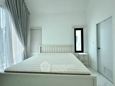 Spacious bedroom with large window and modern minimalist decor